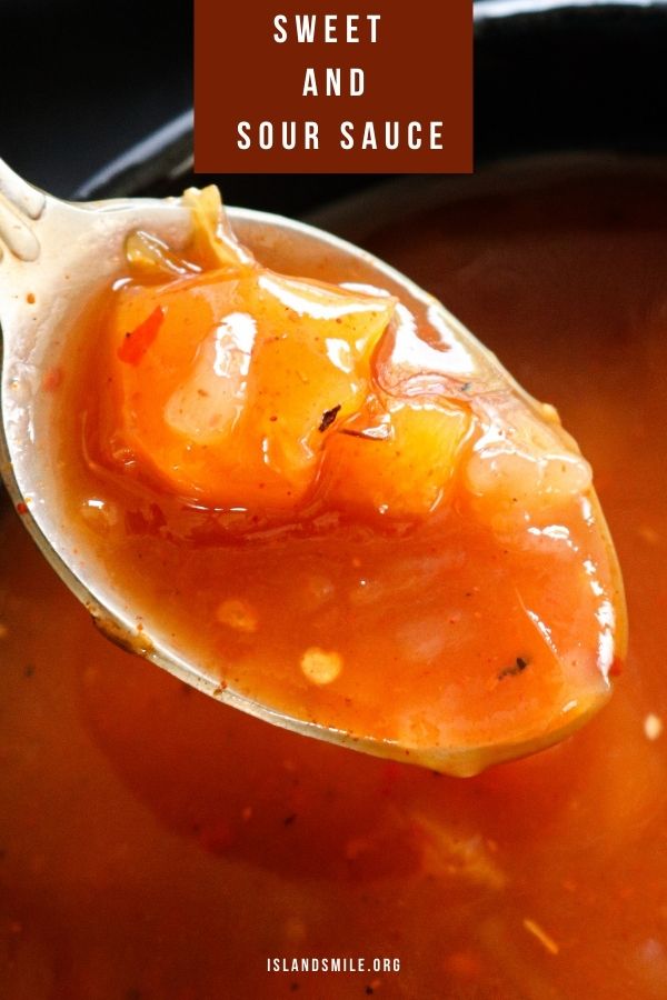 sweet and sour pineapple sauce scooping with a spoon with chunks of pineapple pieces