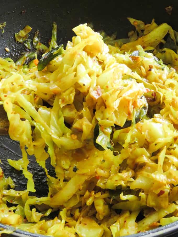 cabbage stir fry scooped with a wooden spoon