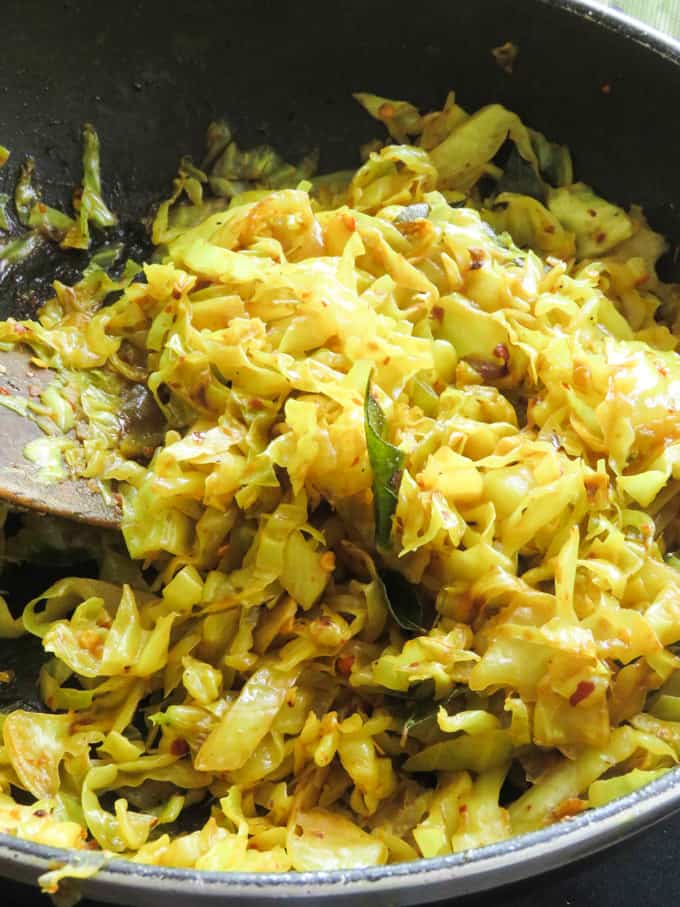cabbage stir fried mixing with a wooden spoon.