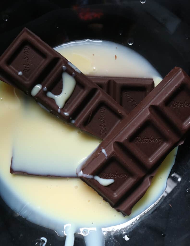 melting chocolate and condensed milk to make the chocolate bread pudding.