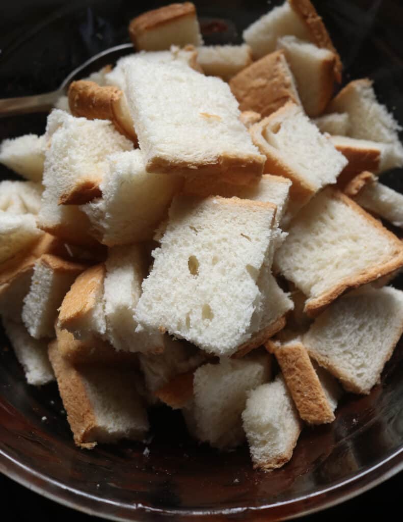 adding the bread cubes to the chocolate mixture to make the bread pudding.