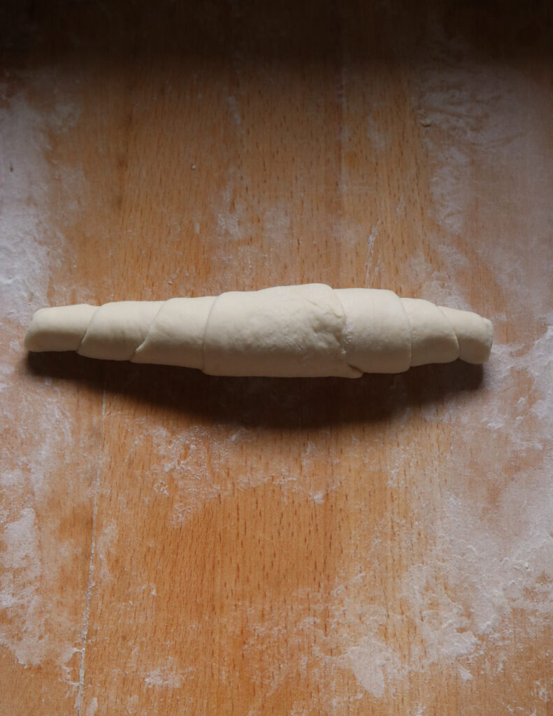 rolling the shape of the dough into a kibula banis.