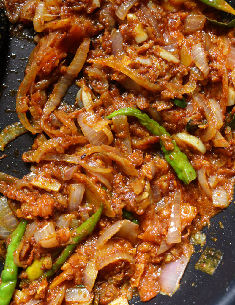 spices added to the frying onions, tomatoes and green chillies to make the soya meat curry.