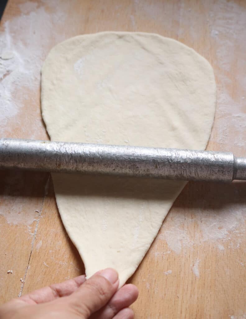 stretching the dough thin with arolling pin.