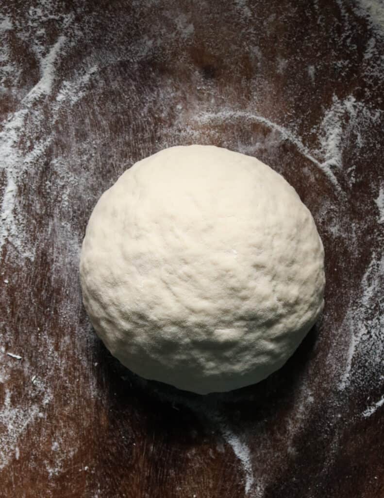 kneaded dough ball on a floured board.