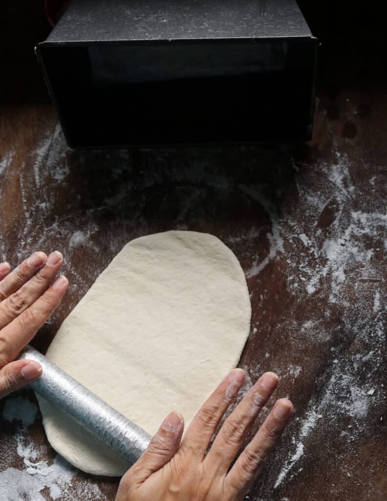 using roller pin to prepare the roast paan(bread)