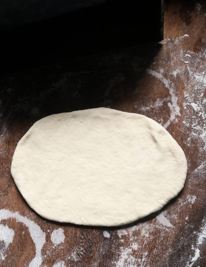 rolling out the dough to make the roast paan.