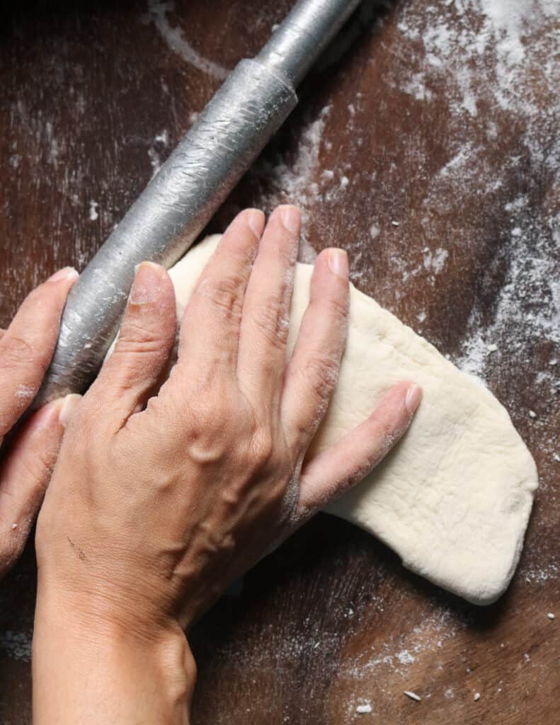 using the roller pin to shape the side to make the roast paan.