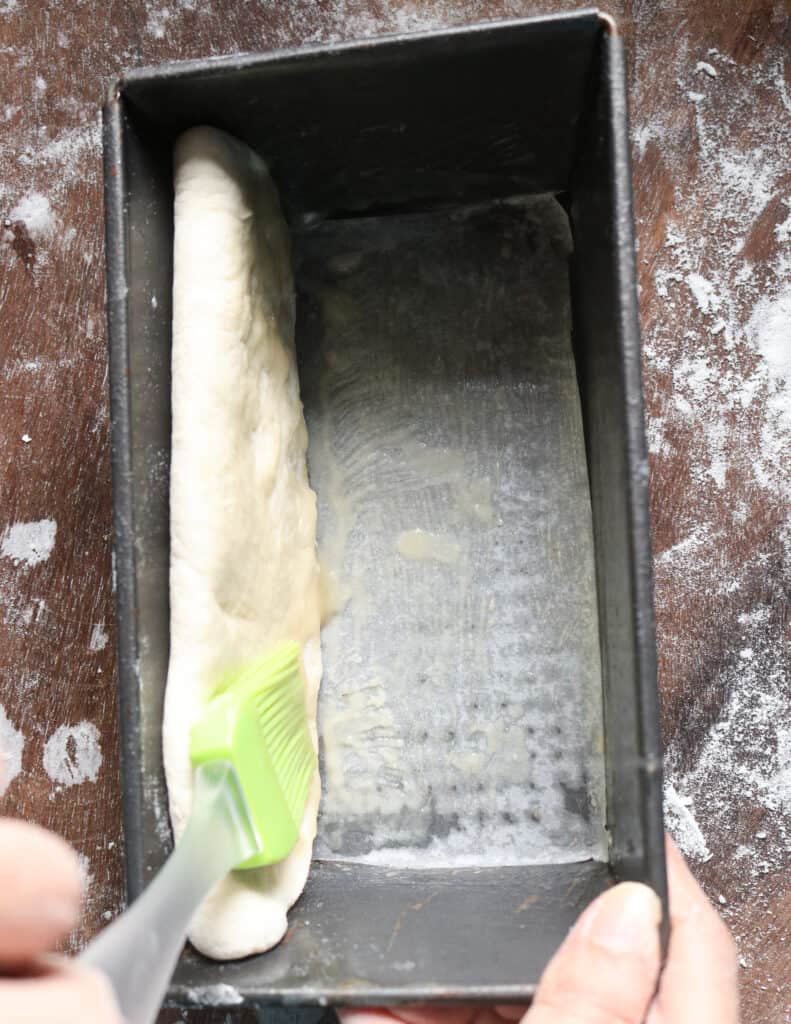 brushing the flour and oil mix while layering the roast paan to bake.