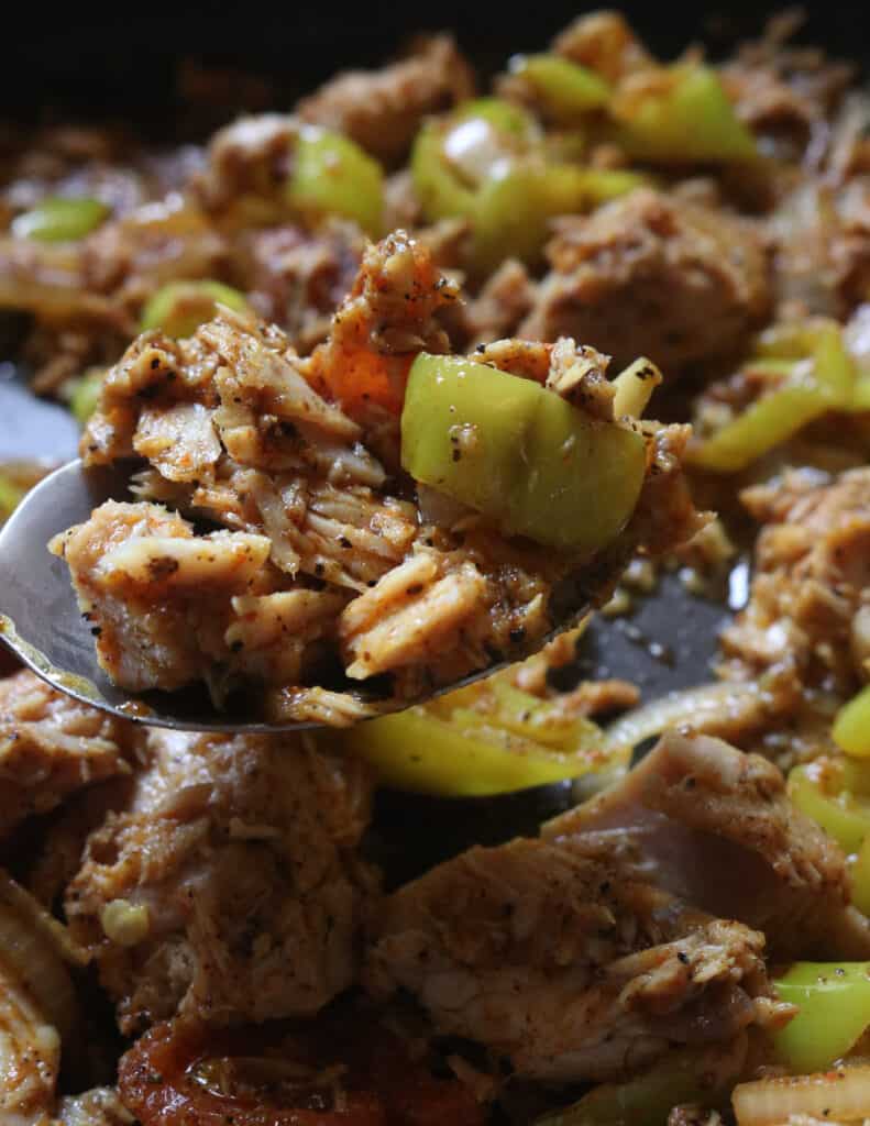 canned tuna chunks with green peppers scooped with a silver spoon