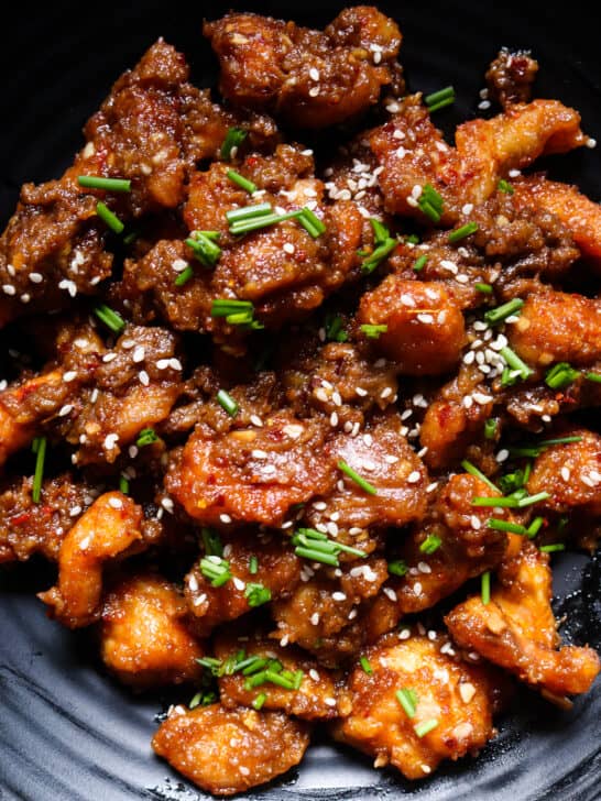 peanut butter chicken on a platter garnished with sesame seeds.