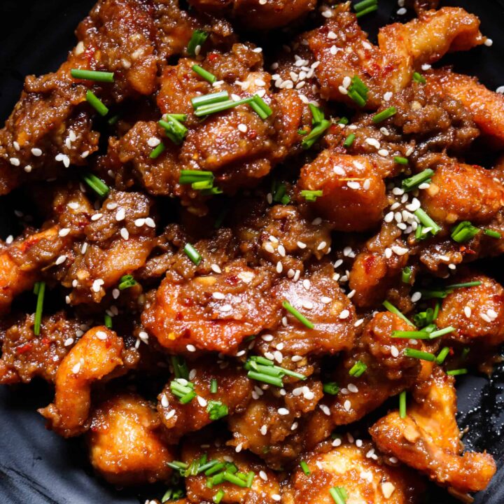 peanut butter chicken on a platter garnished with sesame seeds.