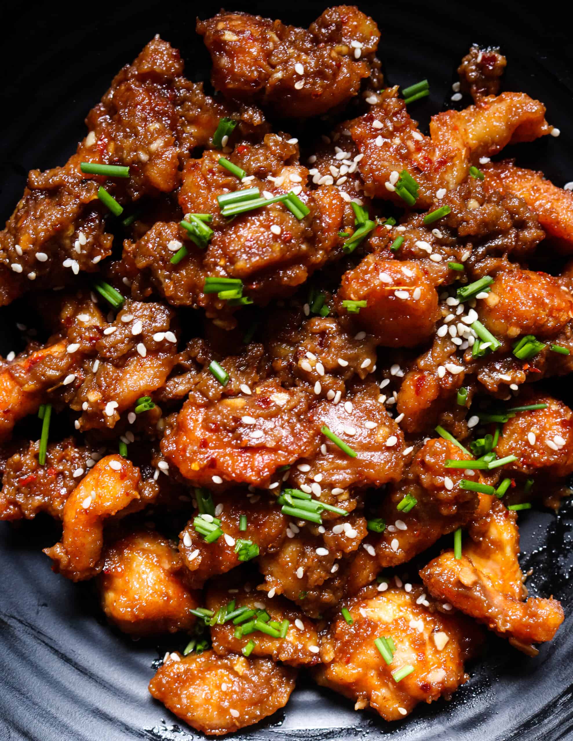 peanut butter chicken on a platter garnished with sesame seeds.