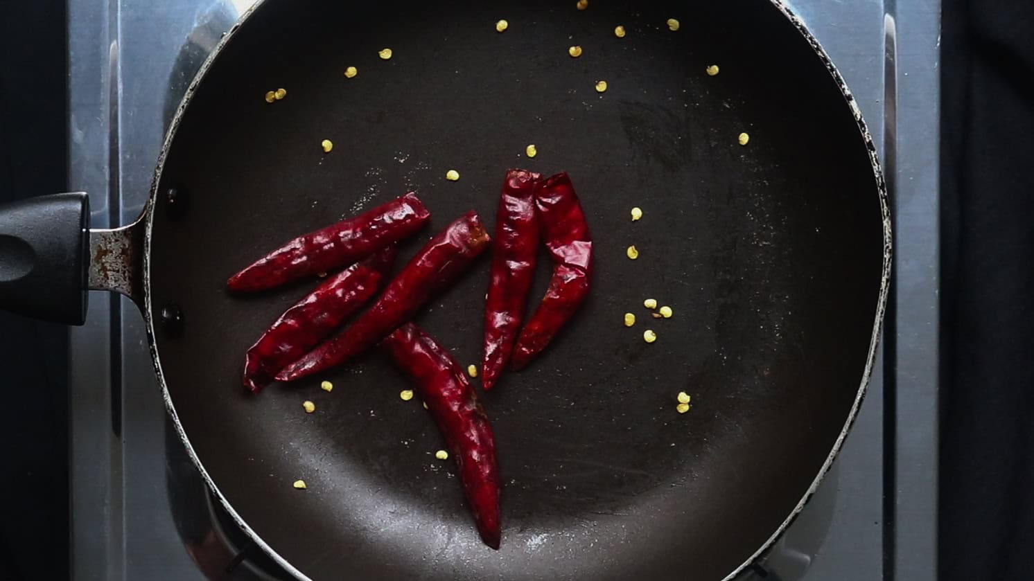 dry roasting the red chillies to cook the beef vindaloo.