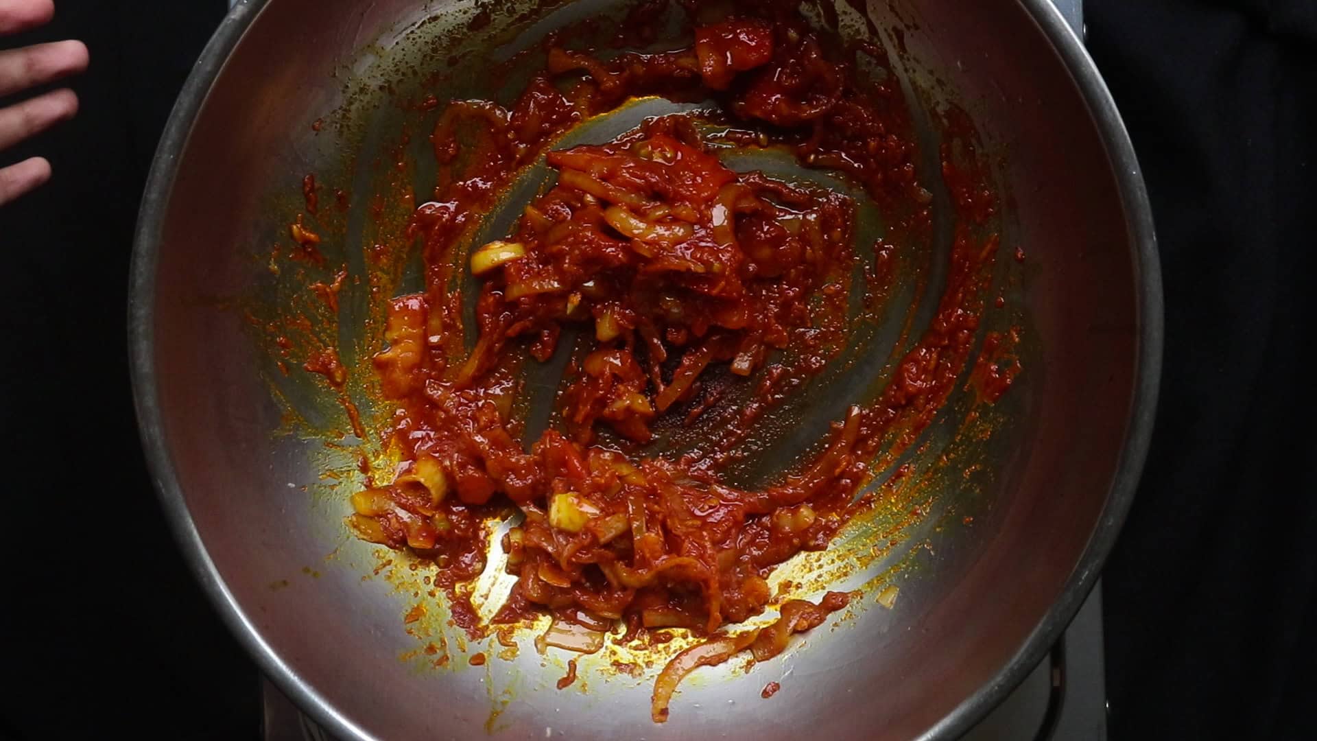 cooking the onions, tomatoes and spices to make a sauce base to cook beef vindaloo.