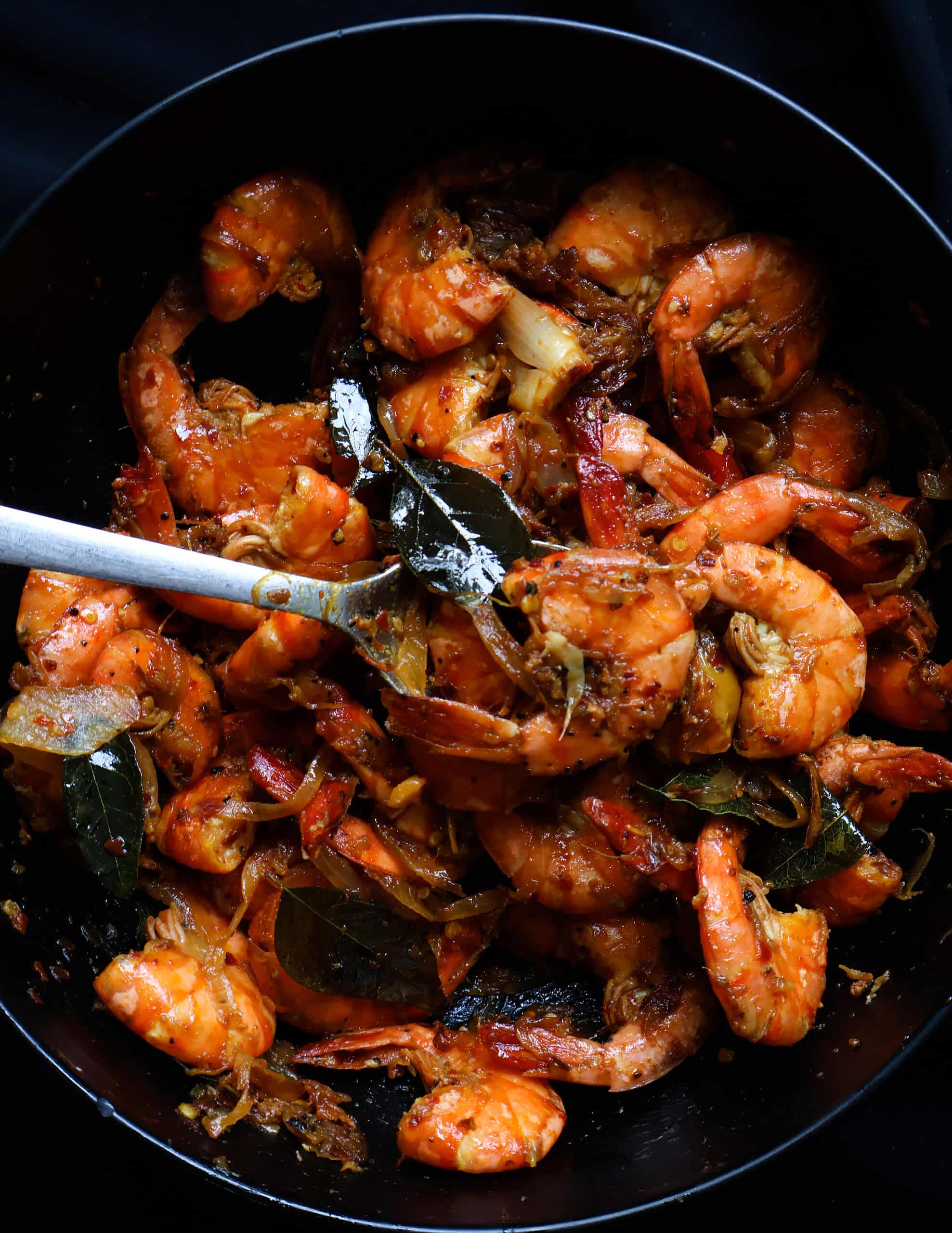 spicy prawn stir fry mixed with a spoon.
