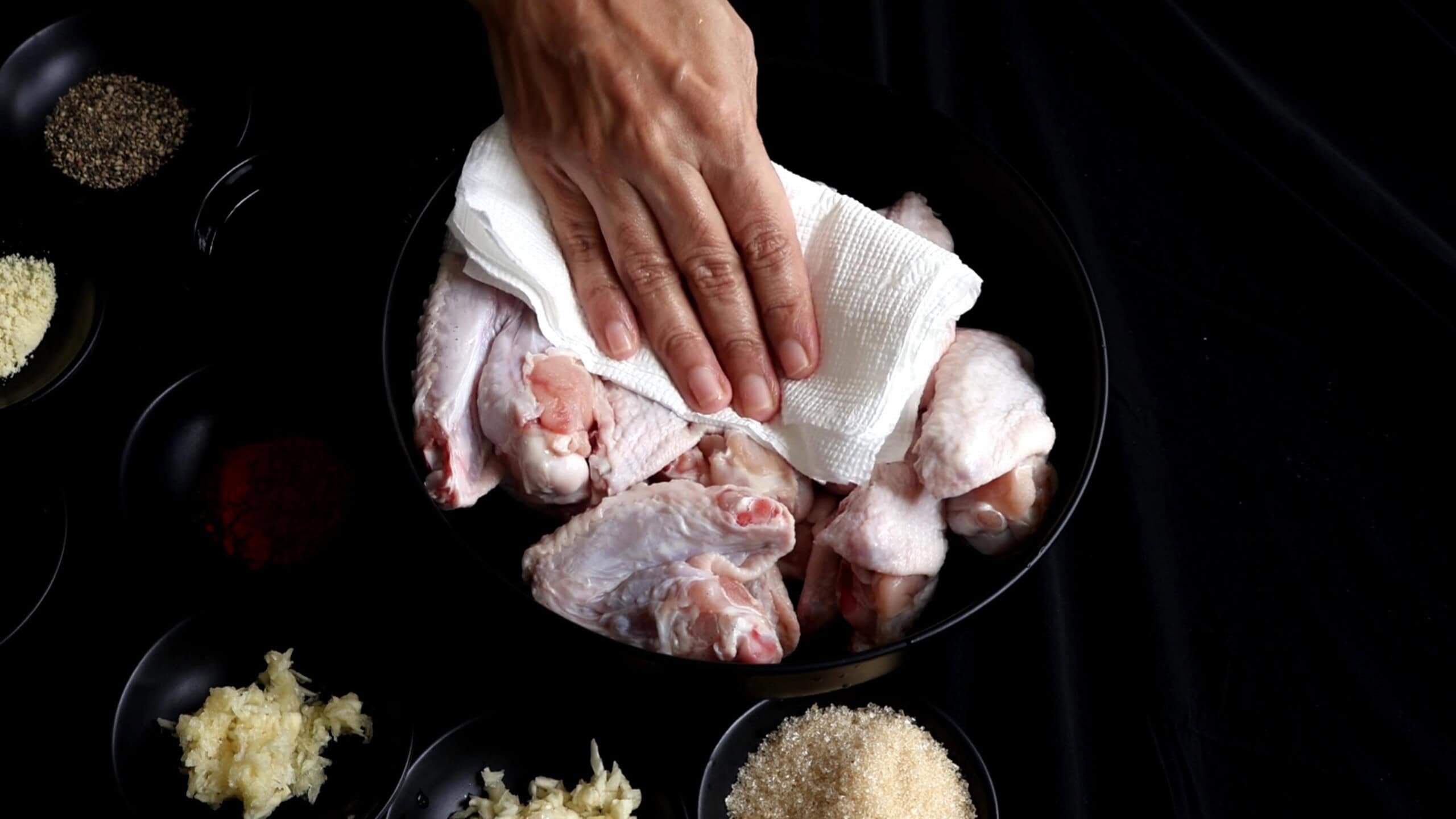 Pat drying the chicken wings before adding the ingredients.