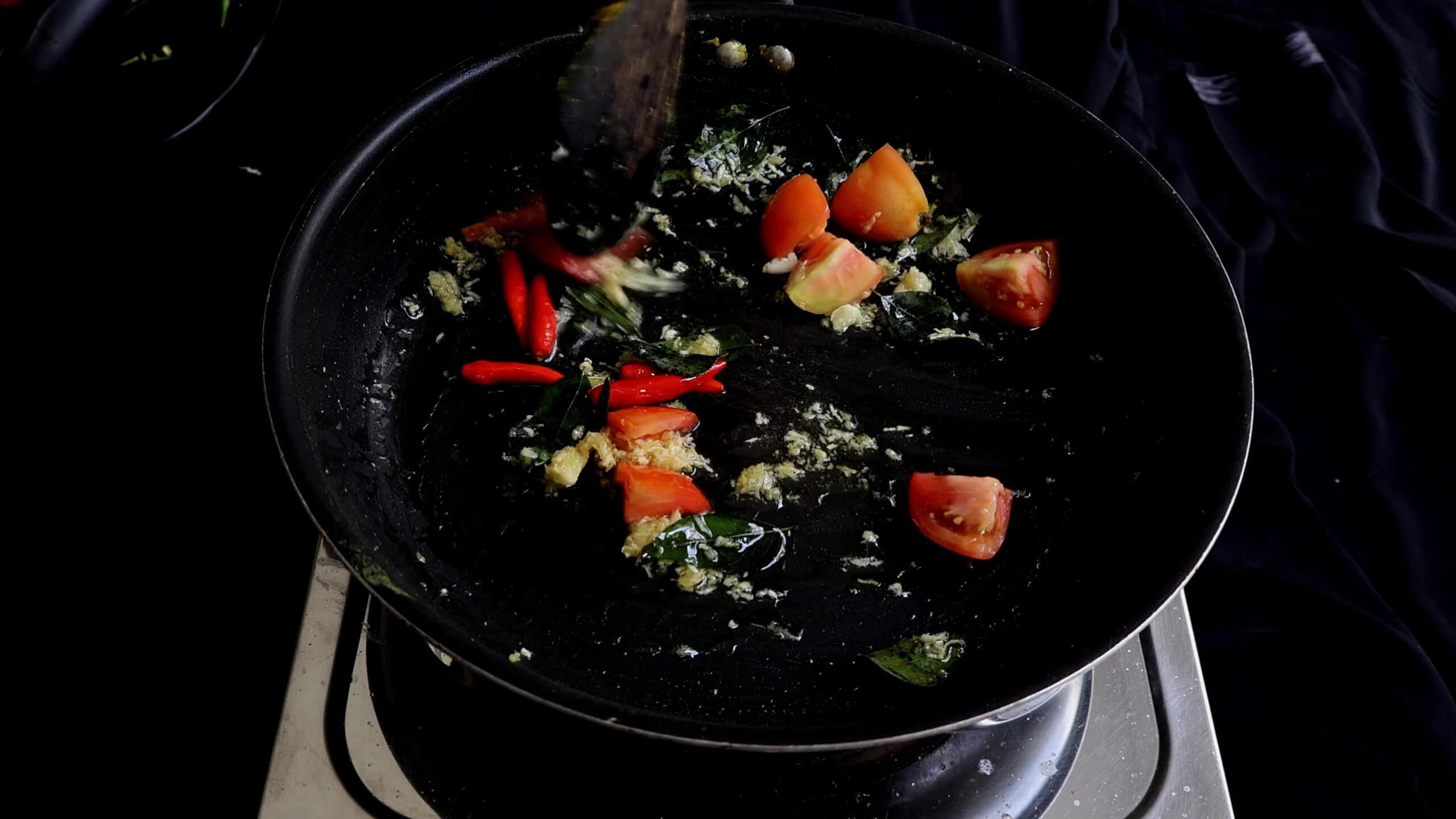 Cooking the chopped onions to cook spicy prawn stir fry.