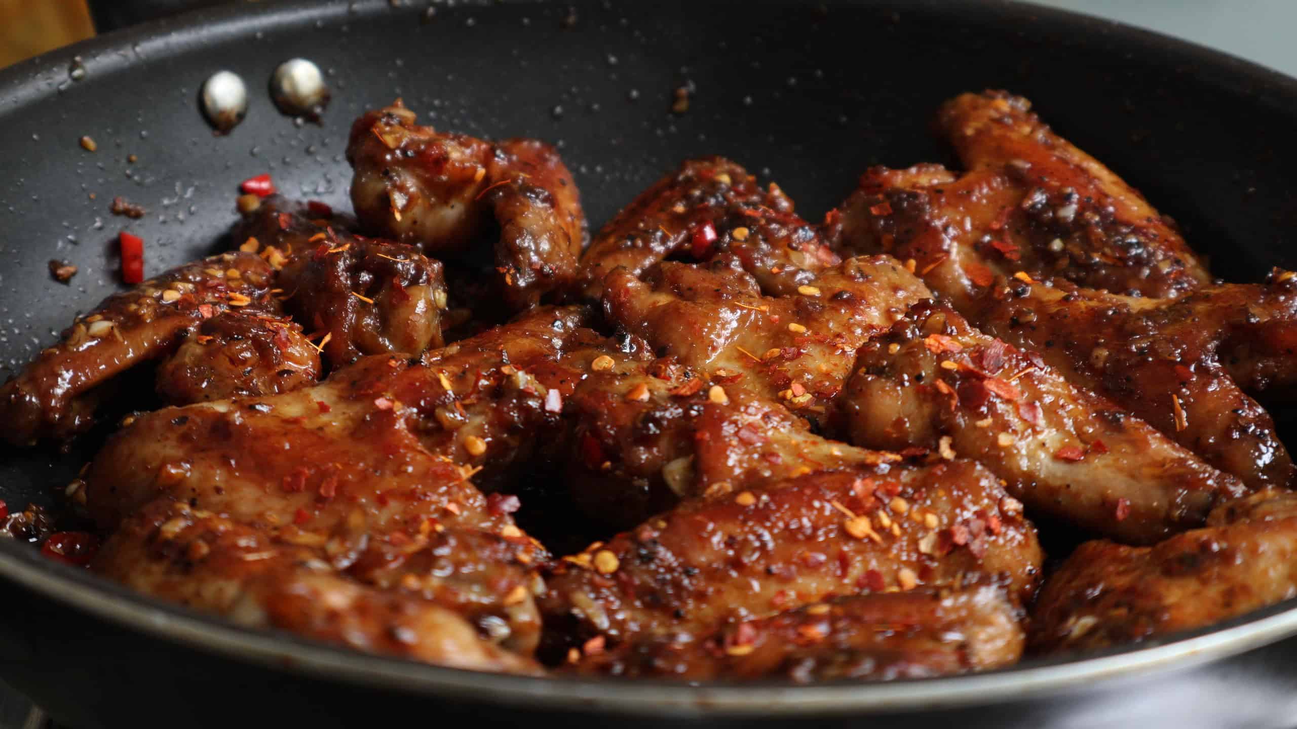 add the wings to the chilli garlic oil to make the stick stove top wings.